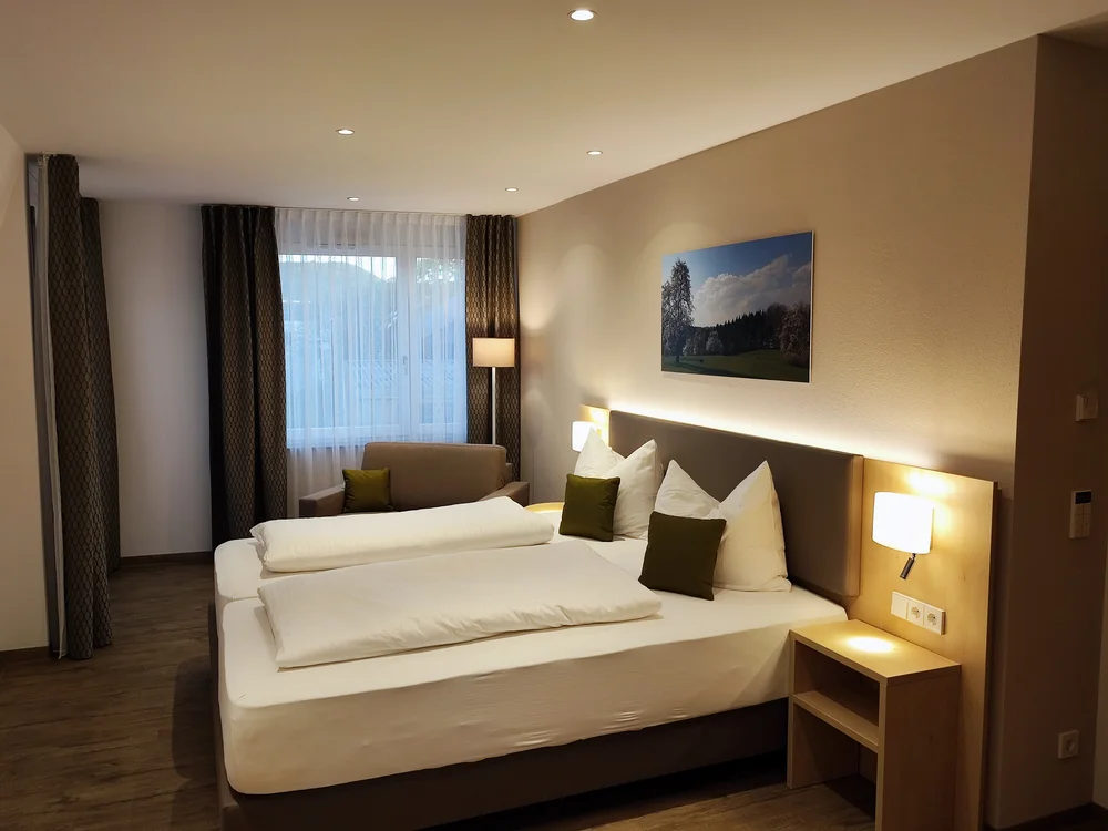 Gemütliches Hotelzimmer mit Doppelbett und Sessel am Fenster