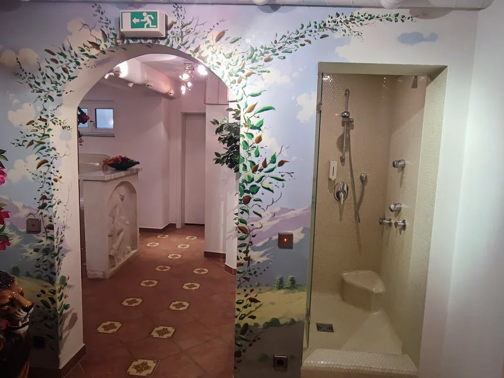 Flur mit bemaltem Bogen und Dusche rechts im Bild