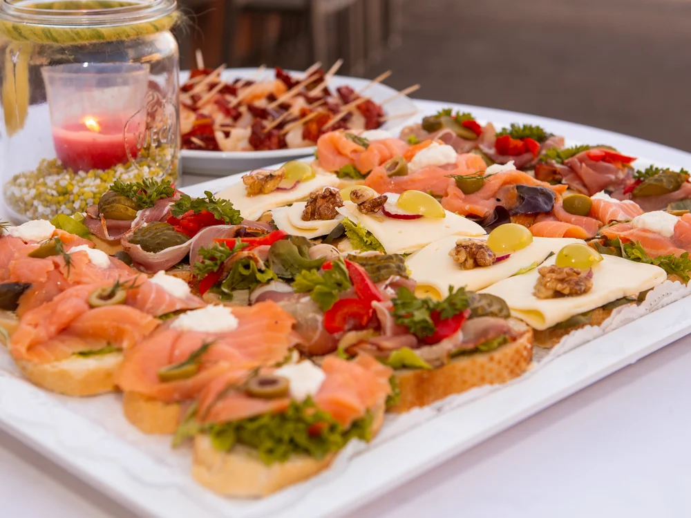 Verschiedene belegte Brote mit Lachs, Käse und Gemüse auf einem Tablett