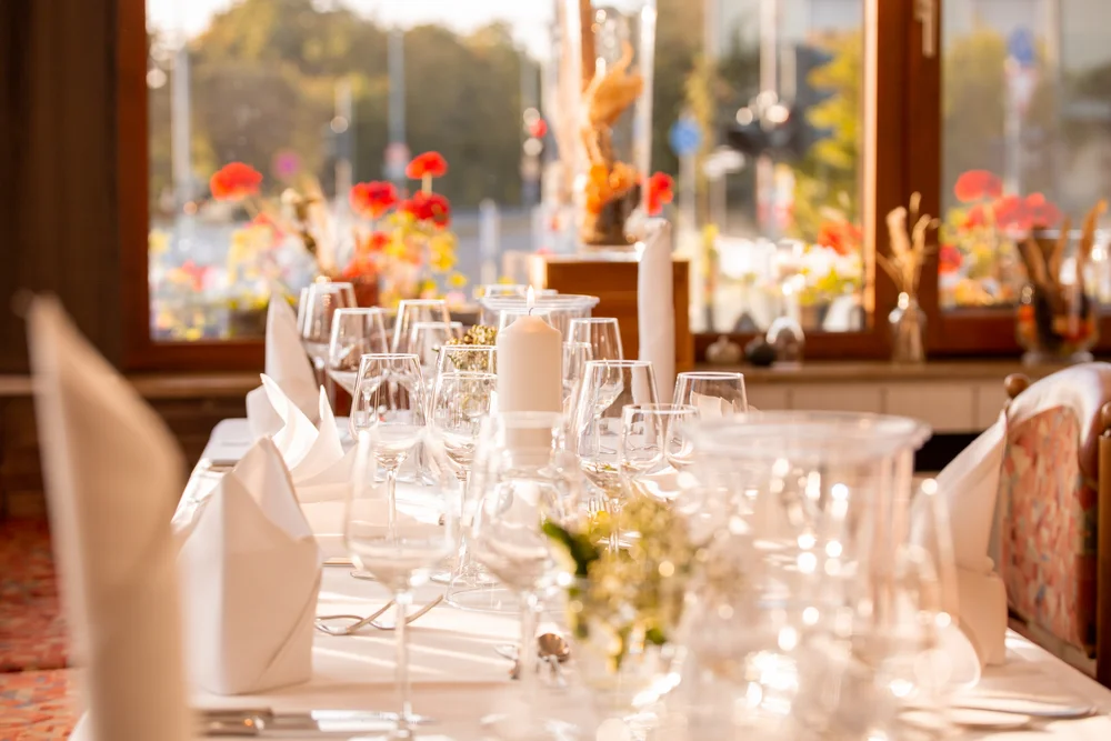 Eleganter Tisch mit Kerzen und Gläsern in einem sonnendurchfluteten Raum