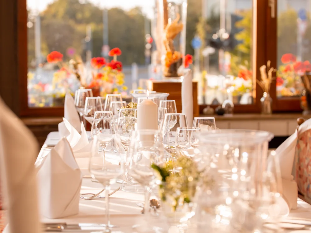 Eleganter Tisch mit Kerzen und Gläsern in einem sonnendurchfluteten Raum